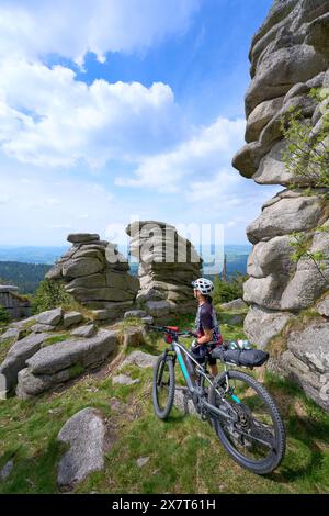 Femme senior active sur un voyage d'emballage de vélo avec son vélo de montagne électrique dans la zone sommitale de la montagne Dresessel dans la forêt bavaroise près de Neurei Banque D'Images