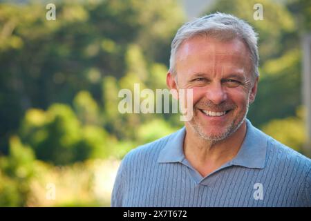 Portrait de rire et sourire homme mature debout à l'extérieur dans la campagne Banque D'Images