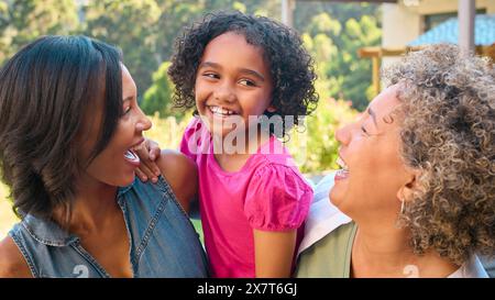 Portrait de la famille féminine de trois générations rire et sourire debout à l'extérieur dans la campagne Banque D'Images