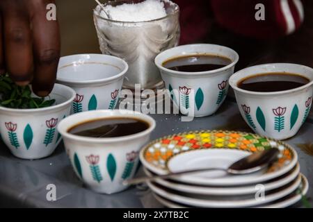 Des grains de café fraîchement torréfiés, un mortier et un pilon avec du jebena et de la fumée d'encens créent une configuration traditionnelle de cérémonie du café éthiopien Banque D'Images