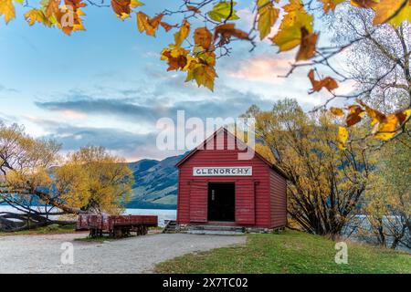 Bâtiment rouge en bois de hangar à bateaux Glenorchy dans la forêt d'automne près du lac Wakatipu dans la soirée à Queenstown, Otago, Nouvelle-Zélande Banque D'Images