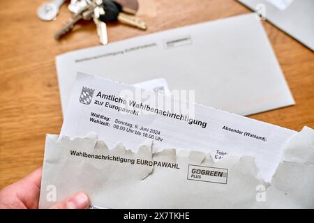 Augsbourg, Bavière, Allemagne - 21 mai 2024 : L'électeur ouvre une lettre avec la notification officielle de l'électeur pour les bulletins de vote pour les élections européennes de 2024 en Allemagne *** Wähler öffnet einen Brief mit der Amtlichen Wahlbenachrichtigung für die Wahlunterlagen zur Europawahl 2024 in Deutschland Banque D'Images