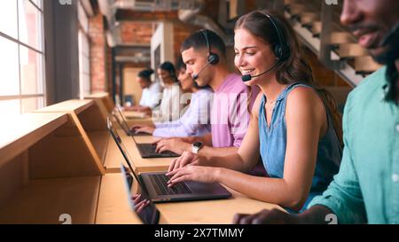 Équipe d'assistance client multiculturelle ou de télévente dans un bureau moderne ouvert portant des micro-casques Banque D'Images