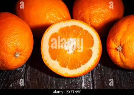 tranches d'oranges blondes ovales calabriennes sur fond de bois noir Banque D'Images