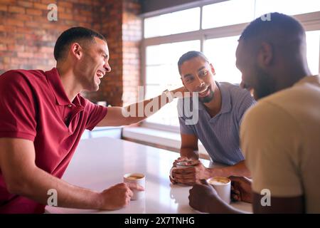 Hommes d'affaires multiculturels prenant une pause café dans la zone de cuisine du bureau moderne ouvert ensemble Banque D'Images