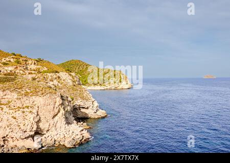 Vue sur la mer Méditerranée avec l'île de Benidorm et les falaises rocheuses du chemin de randonnée falaise près de Villajoyosa. La Vila Joiosa - ville côtière, Valencian Comm Banque D'Images