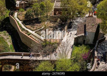 Les touristes traversent l'ancien pont arabe au-dessus des thermes romains, le long de la vieille muraille de la ville à Ronda, province de Malaga, en Espagne. Banque D'Images