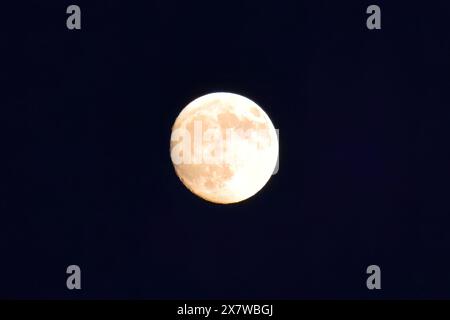 Paysage étonnant de lune brillante blanche avec des cratères dans le ciel noir avec des nuages la nuit Banque D'Images