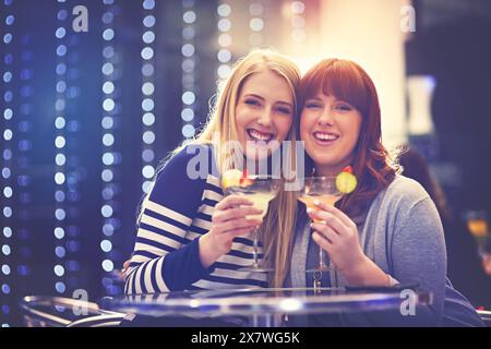 Femmes, amis et portrait dans la boîte de nuit avec boisson cocktail pour événement de fête ou célébration, anniversaire ou alcool. Les femmes, le visage et le plaisir de boire Banque D'Images