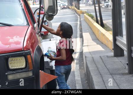 Une jeune fille migrante vénézuélienne d'un campement dans le quartier de Misterios à Mexico vendant des bonbons dans la rue Banque D'Images