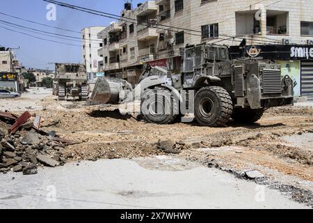 Jénine, Palestine. 21 mai 2024. Un bulldozer militaire israélien détruit l'infrastructure du camp de réfugiés de Djénine, dans le nord de la Cisjordanie, au cours d'une opération militaire à la recherche de militants palestiniens de la brigade de Djénine. Dans le camp du nord de la Cisjordanie, au cours d'une opération militaire à la recherche de militants palestiniens de la brigade de Djénine. Le ministère palestinien de la santé a déclaré que 7 civils palestiniens avaient été tués, dont deux médecins, un enseignant et un étudiant qui se rendait à l’école pendant l’opération militaire. Crédit : SOPA images Limited/Alamy Live News Banque D'Images