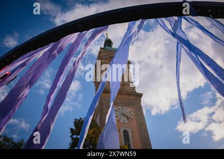 Des rubans de tissu jaunes et bleus flottent dans le vent sur le fond d'un ciel bleu et d'une ancienne tour de l'horloge. Banque D'Images