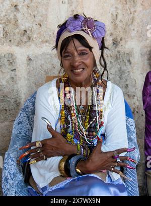 Femme cubaine avec des ongles très longs sourires montrant ses ongles longs et colorés. Banque D'Images