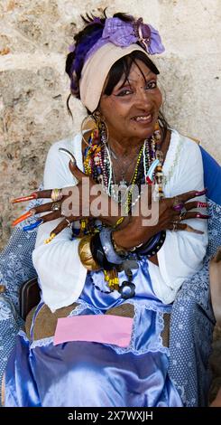 Femme cubaine avec des ongles très longs sourires montrant ses ongles longs et colorés. Banque D'Images