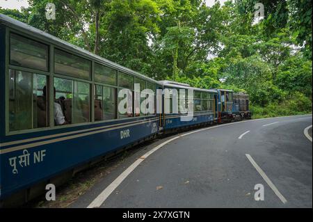 Darjeeling, Bengale occidental, Inde - 10 août 2023 : train diesel jouet passant par les routes et la jungle himalayennes. Darjeeling Himalayan Railway. Banque D'Images