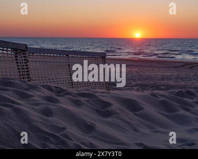 Coucher de soleil sur la mer avec des dunes de sable au premier plan et atmosphère calme, coucher de soleil spectaculaire sur la mer avec des bateaux à voile au premier plan, de haan, b Banque D'Images