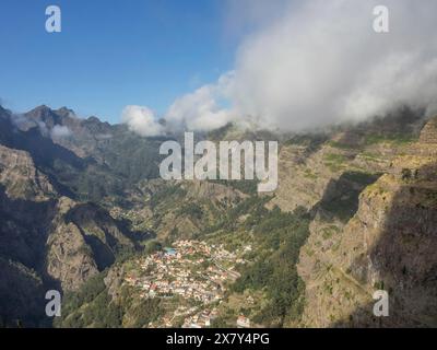 Immense paysage de montagne avec un village dans la vallée par temps ensoleillé et nuages dispersés, nuages sur de hautes montagnes avec de petits villages de montagne en t Banque D'Images