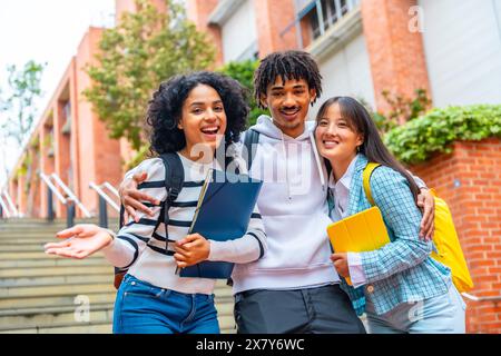 Portrait de vue en angle bas de trois étudiants heureux posant souriant à la caméra dans le campus Banque D'Images