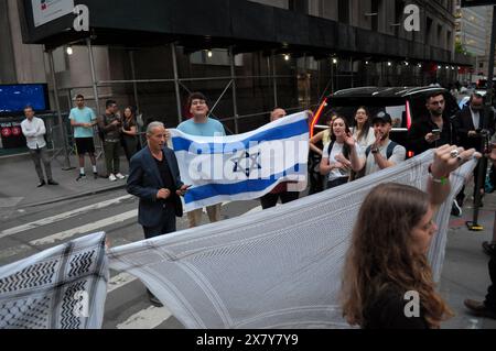 Les partisans israéliens brandissent le drapeau israélien près d'un rassemblement pro-palestinien à l'extérieur de Cipriani Wall Street. Des manifestants pro-palestiniens se sont rassemblés à Manhattan, New York City, condamnant la 75e prestation annuelle de Parsons organisée par la New School de Cipriani Wall Street. Les étudiants et les professeurs de la New School ont demandé à l'école de couper les relations d'affaires avec les entreprises liées à Israël. Dans le contexte de la guerre israélo-Hamas en cours, le procureur en chef de la Cour pénale internationale sollicite des mandats d’arrêt contre le premier ministre israélien Benjamin Netanyahu et le dirigeant du Hamas à Gaza. Le procureur Banque D'Images