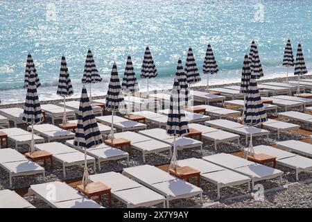 Vue sur la plage avec chaises longues et parasols fermés à Nice, sur la côte méditerranéenne Banque D'Images