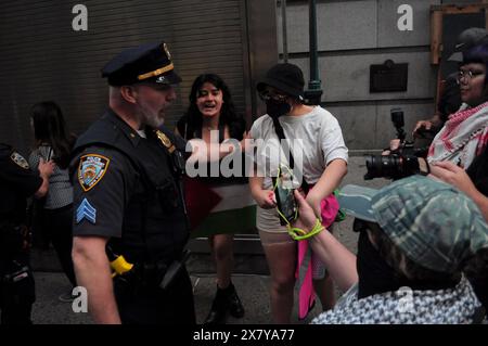 Des manifestants pro-palestiniens s'affrontent avec un membre du département de police de New York lors d'un rassemblement devant Cipriani Wall Street. Des manifestants pro-palestiniens se sont rassemblés à Manhattan, New York City, condamnant la 75e prestation annuelle de Parsons organisée par la New School de Cipriani Wall Street. Les étudiants et les professeurs de la New School ont demandé à l'école de couper les relations d'affaires avec les entreprises liées à Israël. Dans le contexte de la guerre Israël-Hamas en cours, le procureur en chef de la Cour pénale internationale sollicite des mandats d’arrêt contre le premier ministre israélien Benjamin Netanyahu et le leader O. Banque D'Images