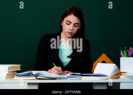 Le nouveau professeur vérifie les devoirs. Étudiante attirante ou nouvelle enseignante. Apprentissage de la langue et concept d'éducation. Jeune enseignante. Le Banque D'Images