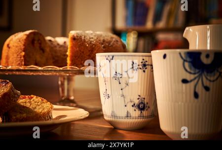 Tasse de luxe à l'ancienne de café chaud avec une tranche de beignet gf dans un environnement romantique. Ambiance chaleureuse avec beignet tranché et une tasse de thé luxueuse Banque D'Images