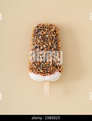 Crème glacée popsicle sur fond de crème pastel. Concept estival minimal. Esthétique de la crème glacée. Pose à plat. Banque D'Images