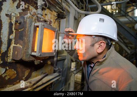 homme utilisant un four dans une usine Banque D'Images