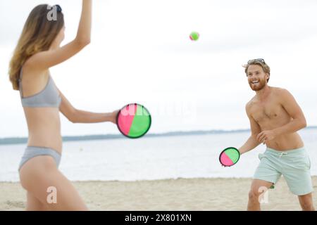 groupe d'amis jouant sur la plage Banque D'Images