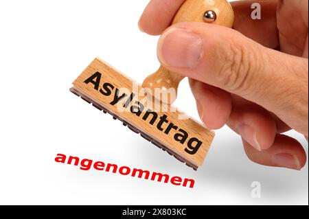 Asylantrag angenommen Ein Holzstempel in der hand mit Aufschrift Asylantrag und dem Abdruck angenommen *** demande d'asile acceptée Avec Un tampon en bois Banque D'Images