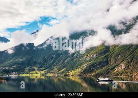 Traversée en ferry pittoresque Geirangerfjord en Norvège entouré de montagnes brumeuses Banque D'Images