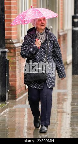 Une femme avec un parapluie à Leeds. De fortes pluies pourraient provoquer des inondations et perturber les transports dans une grande partie du Royaume-Uni mercredi et jeudi, avec un avertissement orange émis pour une partie du pays. Date de la photo : mercredi 22 mai 2024. Banque D'Images