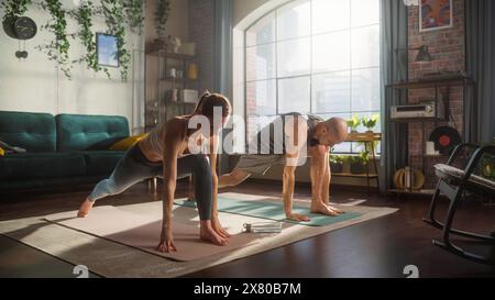 Athlétique jeune couple s'exerçant ensemble, s'étirant et faisant du yoga le matin dans Sunny Room at Home. Bel homme et femme en vêtements de sport pratiquant différentes poses Asana sur le tapis. Banque D'Images