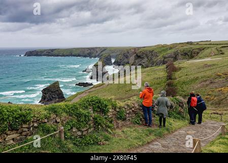 Ramblers appréciant la vue spectaculaire sur la côte à Bedruthan Steps North Cornwall par un jour de printemps orageux Angleterre Royaume-Uni Banque D'Images