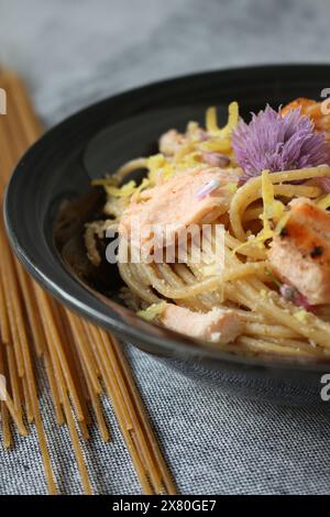 Pâtes au citron avec saumon et fleurs comestibles Banque D'Images