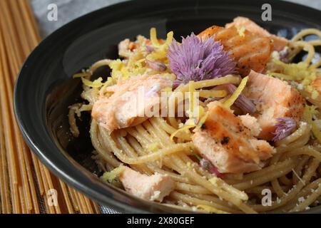 Pâtes au citron avec saumon et fleurs comestibles Banque D'Images