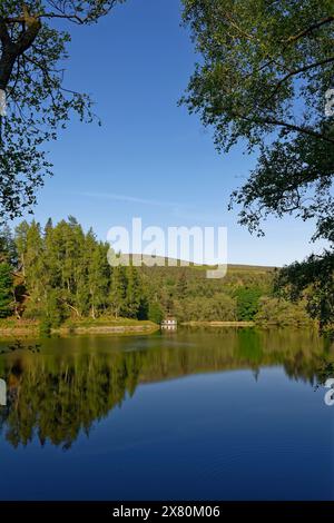 La vue vers l'ouest sur le réservoir Glen Ogil un tôt le matin sur le Wooden Boathouse sur les marges du lac. Banque D'Images