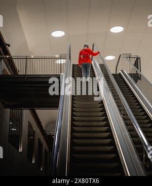 Une personne voyageant sur l'ascenseur et approchant du sommet. Personne d'autre dans l'ascenseur. Architecture moderne à l'intérieur d'un bâtiment. ascenseur raide Banque D'Images