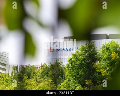 Bâle, Suisse - 18 mai 2024 : Siège de Novartis ou Novartis Campus, un bâtiment moderne entouré de verdure sous un ciel nuageux Banque D'Images