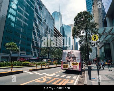 Manille, Philippines - 26 août 2019 : rue animée de l'après-midi dans la ville de Makati avec bus public et immeubles de grande hauteur Banque D'Images