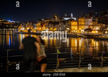 Jeune couple sur le quai vers Cais da Ribeira la nuit, Porto, Portugal Banque D'Images