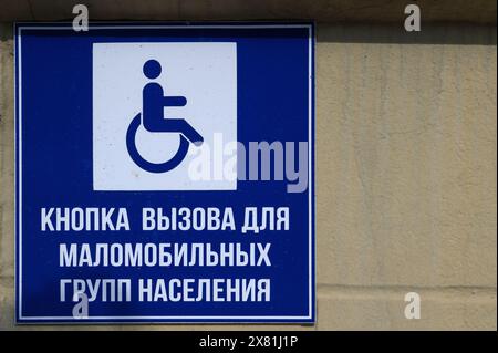 Saransk, Russie - 5 juin 2023. Bouton d'appel pour personnes handicapées. Panneau jaune indiquant une personne en fauteuil roulant en fauteuil roulant et un appel Banque D'Images