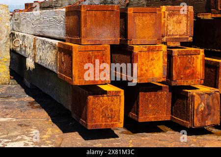 Planches de bois recouvertes d'acier rouillé utilisées comme défenses maritimes à l'entrée du port. Le pittoresque village de pêcheurs de Mousehole, Cornouailles, West Country, E. Banque D'Images