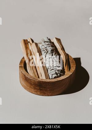 Sauge blanche et Palo Santo bâtons dans une boîte en bois sur un fond clair. Un ensemble d'encens pour la fumigation. Vue de face. Banque D'Images