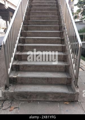 L'escalier en béton du pont supérieur près de la jonction dans la ville, garde-corps en acier inoxydable le long du chemin, vue de face avec l'espace de copie. Banque D'Images