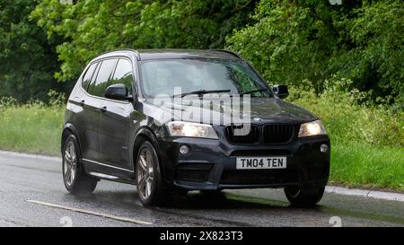 Stony Stratford, Royaume-Uni - 22 mai 2024 : 2013 BMW X3 voiture conduisant sur une route britannique un jour humide Banque D'Images