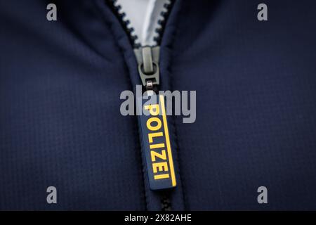 Nuremberg, Allemagne. 22 mai 2024. Le mot « police » est écrit sur la fermeture éclair de la veste d'un policier. Crédit : Daniel Karmann/dpa/Alamy Live News Banque D'Images