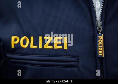 Nuremberg, Allemagne. 22 mai 2024. Le mot « police » est écrit sur la tirette de fermeture éclair et sur la veste d'un policier. Crédit : Daniel Karmann/dpa/Alamy Live News Banque D'Images