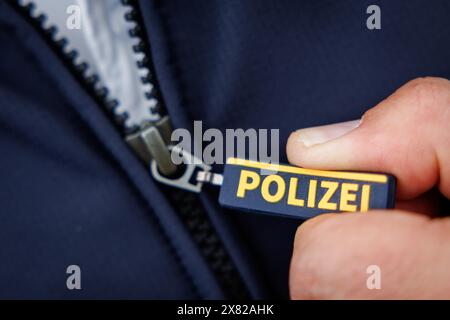 Nuremberg, Allemagne. 22 mai 2024. Le mot « police » est écrit sur la fermeture éclair de la veste d'un policier. Crédit : Daniel Karmann/dpa/Alamy Live News Banque D'Images